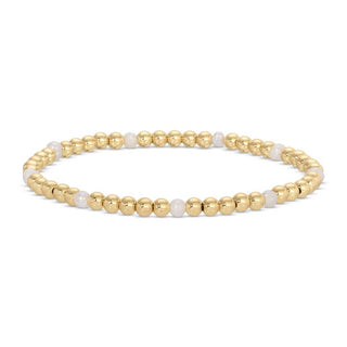 Gold and white beaded bracelet on a white background