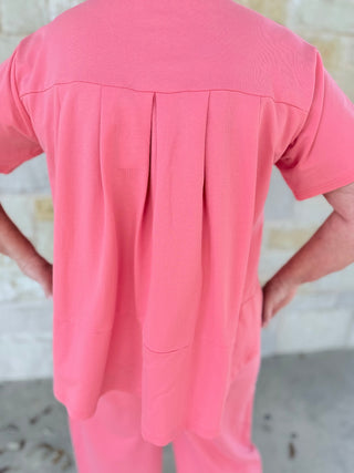 Person wearing a pink outfit with a blurred background