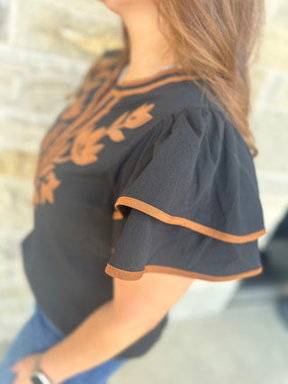 Solid crinkle top with floral applique detail