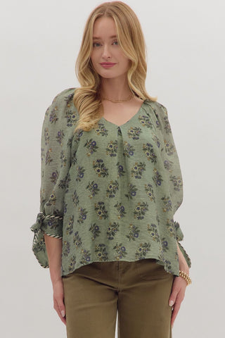 Woman wearing a green floral blouse against a white background