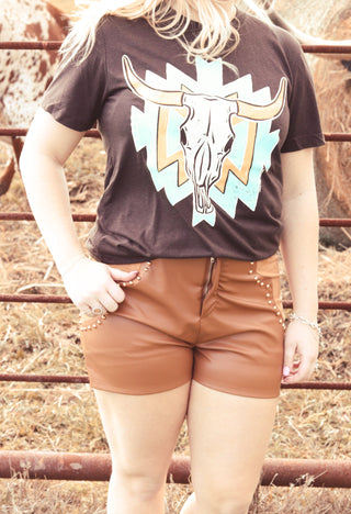 Person wearing a black t-shirt with a bull skull design in an outdoor setting