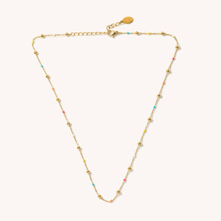 Gold necklace with small beads on a white background