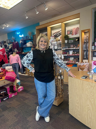 Woman in a store with colorful clothing and products in the background