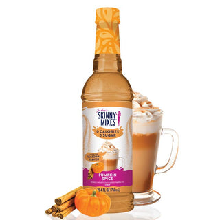 Bottle of Skinny Mixes Pumpkin Spice syrup with a glass of pumpkin spice latte and pumpkins on a white background