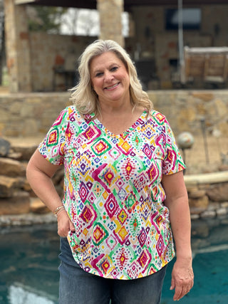 multicolored geometric patterned blouse with a v-neckline and short sleeves.