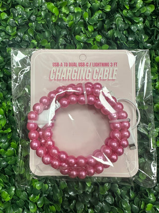 Pink charging cable with packaging on a green grass background